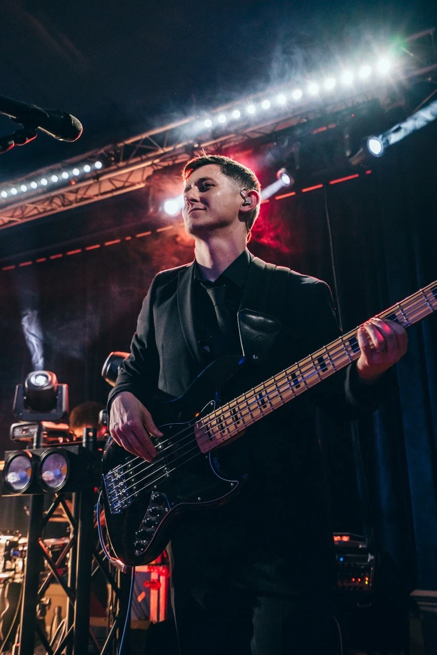 Bassist in suit on stage with professional lighting rig